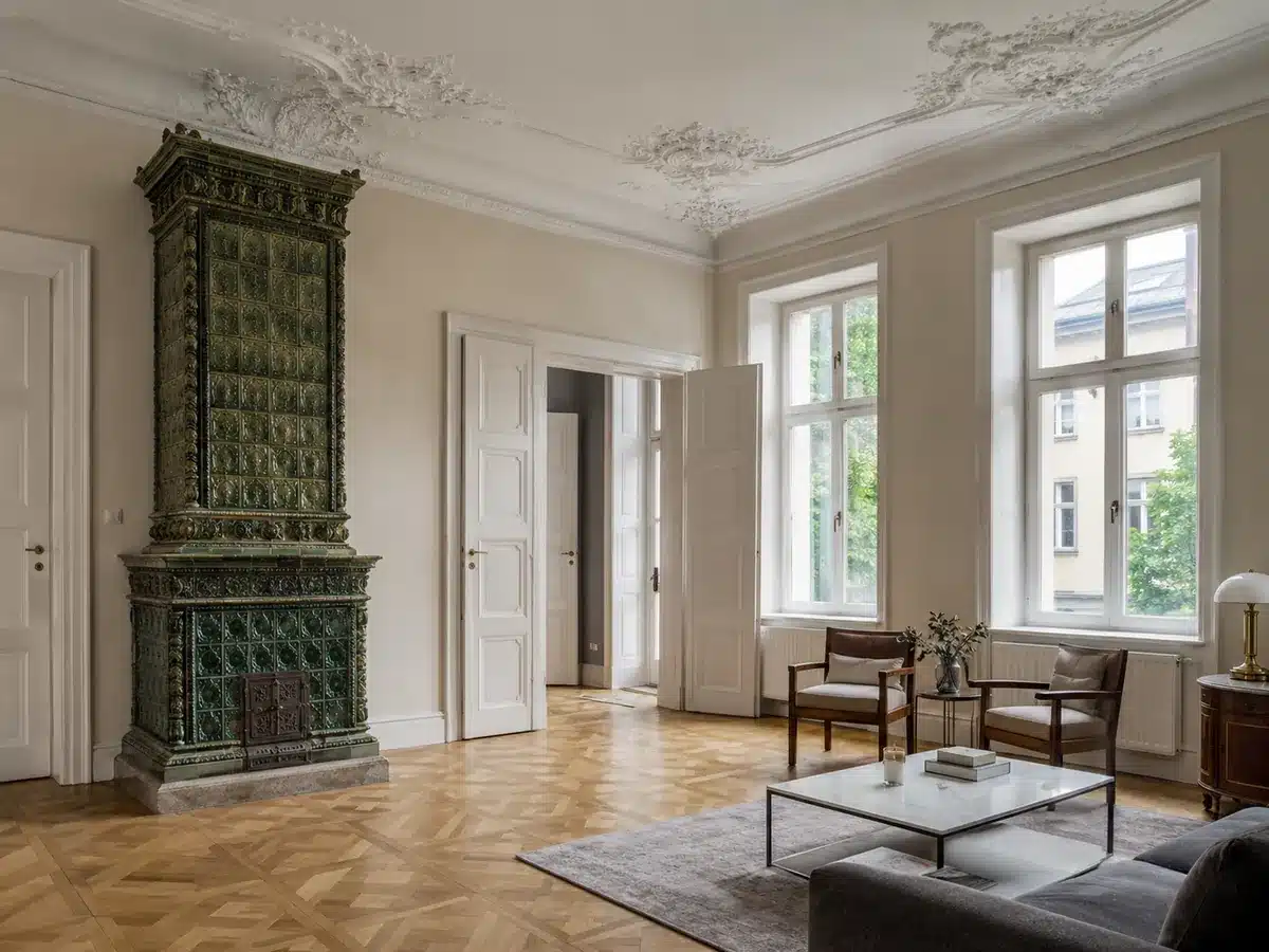 Altbau-Salon mit Stuckdecke und historischem Kachelofen