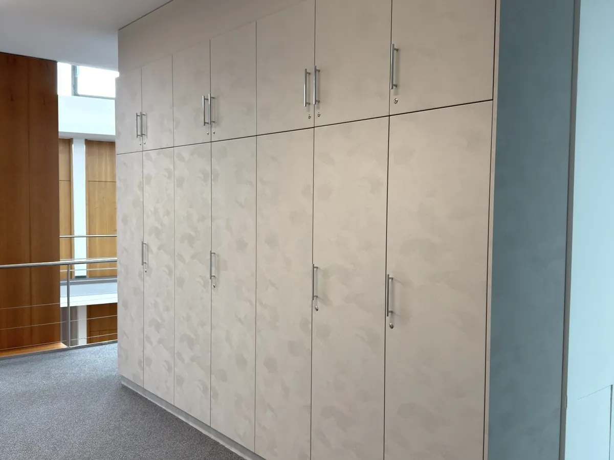 Erneuerte Büro-Schrankwand mit hellen Fronten in Steinoptik auf dem Flur.
