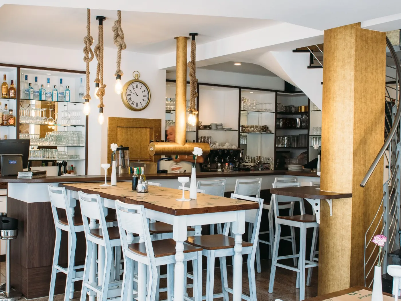 Dieselbe Bar nach der Renovierung: helle Fronten, goldene Säule und Thekenblende, im laufenden Betrieb erneuert.